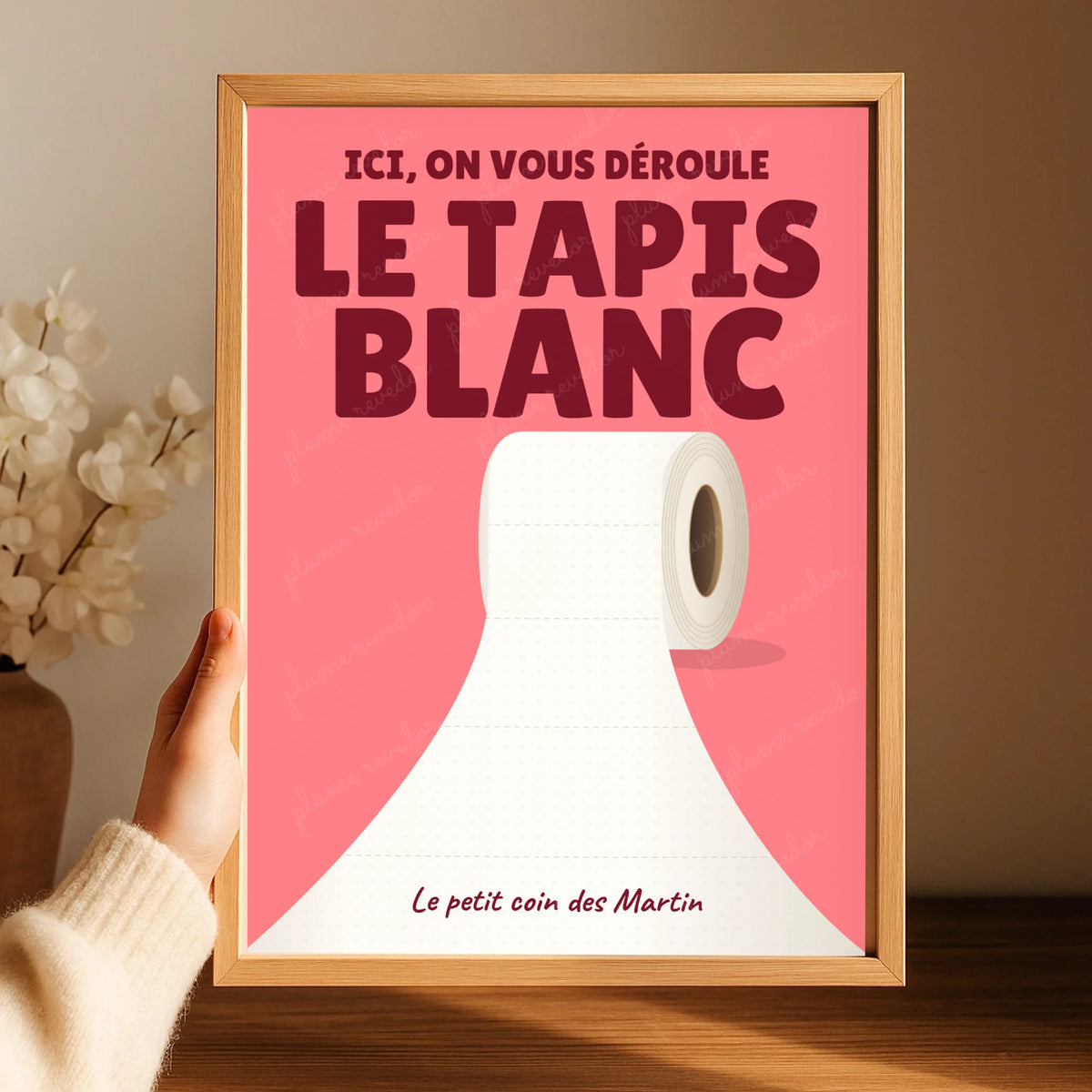 Affiche toilettes Pop corail Le tapis blanc présentée dans un cadre en bois