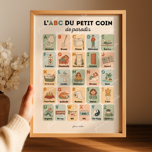 Affiche abécédaire des toilettes dans un cadre en bois, tenue à la main dans une ambiance chaleureuse.