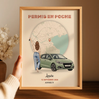 Affiche personnalisée encadrée, tenue à la main près d’un vase de fleurs.