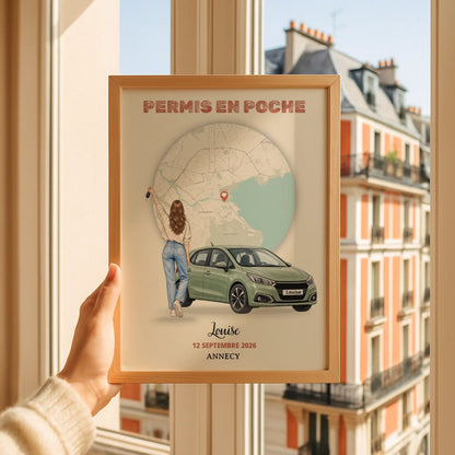 Affiche du permis personnalisée, encadrée et tenue devant une fenêtre avec vue sur la ville.