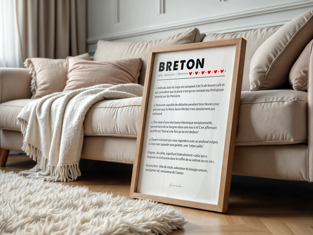 Affiche humoristique définition Breton dans un cadre en bois clair, posée devant un canapé beige.