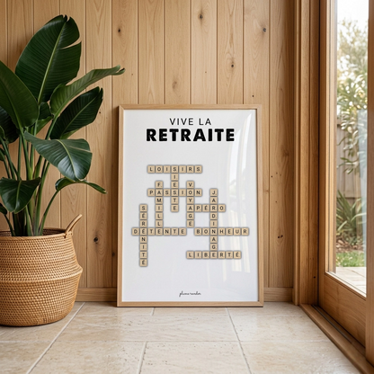 Affiche non personnalisée « Vive la retraite » en mots croisés, dans un cadre clair contre un mur en bois près d’une grande plante.